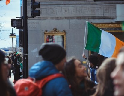 man waving irish republic flag in crowd