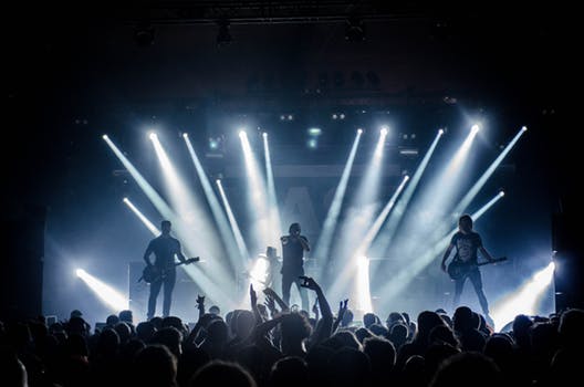 Indoor gig with bands Glasgow performing to huge crowds under strobe lights.